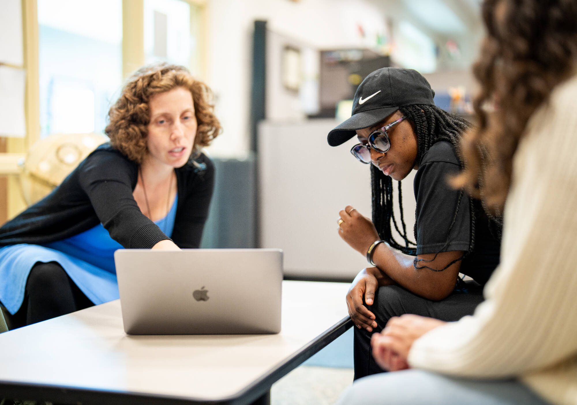 Students and advisor looking at computer